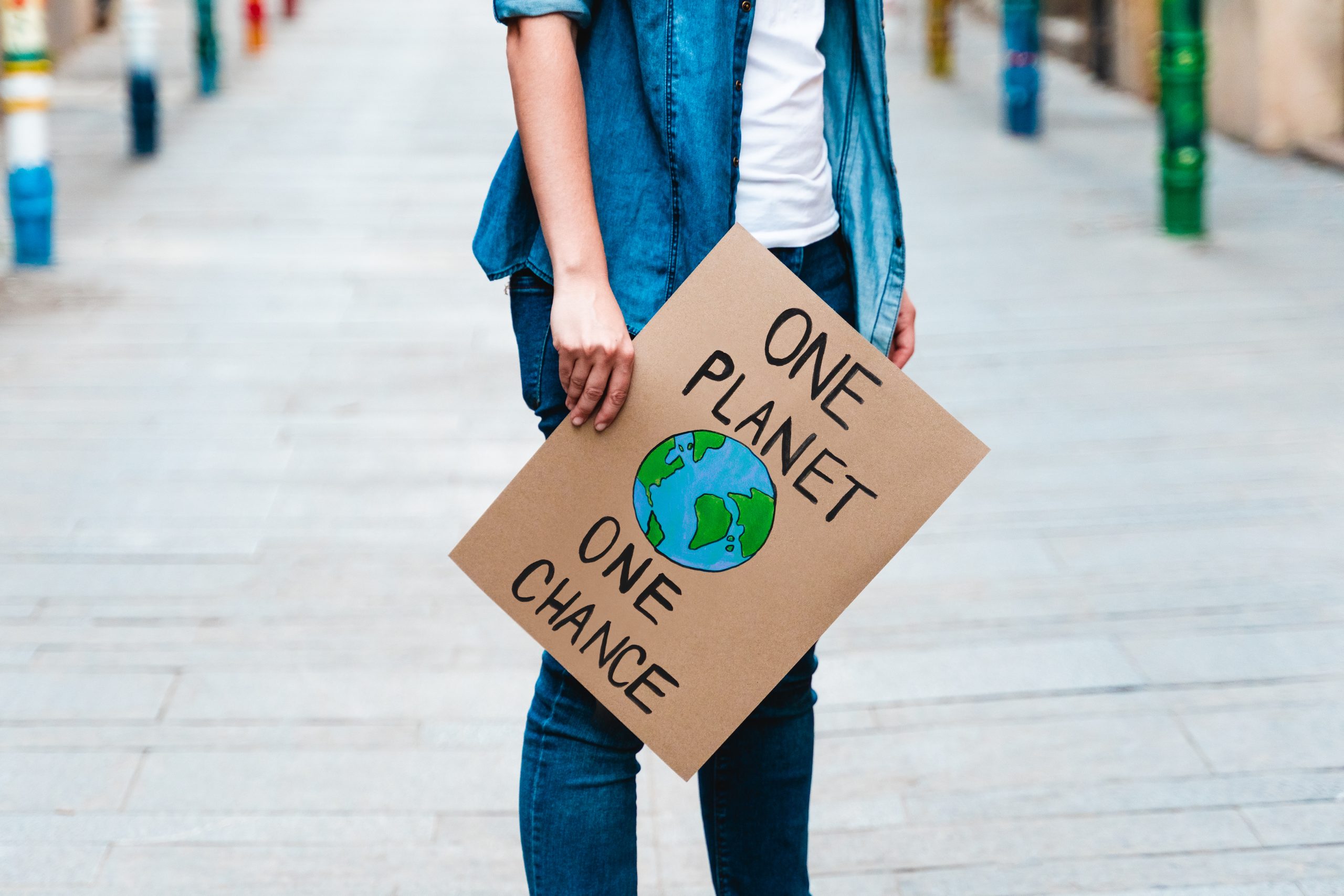 Young activist marching and protesting for climate change holding banner - Ecology concept